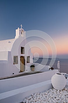 Oia village Santorini with blue domes and whitewashed house during sunset at the Island of Santorini Greece