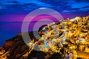 Oia village, windmills, Santorini island, Greece at colorful sunset