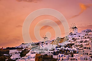 Oia village, windmills, Santorini island, Greece at colorful sunset