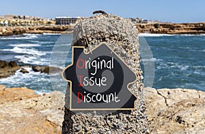 OID original issue discount symbol. Concept words OID original issue discount on beautiful yellow blackboard. Beautiful stone sea