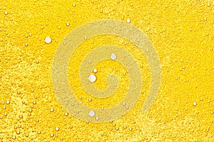 Oil bubbles texture. Cosmetic gold serum background. Abstract bright yellow color oily liquid closeup