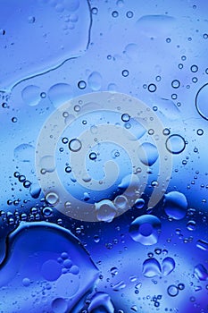 Oil bubbles in water . Blue and black colors tog hater.