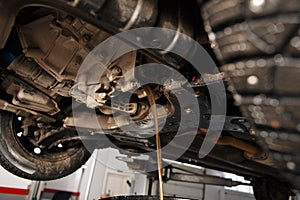 Oil change in automatic transmission. Filling the oil through the hose. Car maintenance station. Red gear oil. The hands
