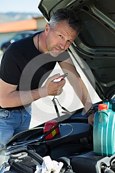 Oil change in car. Man repairing the engine in the car. Self-changing oil in own car.