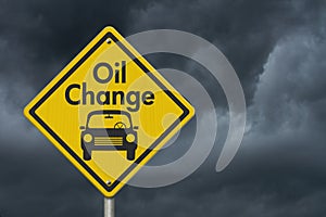 Oil change with car on yellow warning highway road sign