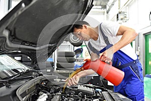 oil change from the engine of a car in a workshop by a professional mechanic - after-sales service