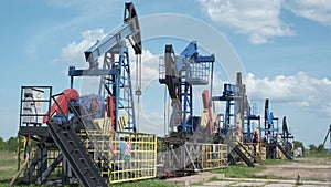 Oil derricks against cloudy sky