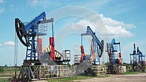 Oil derricks against cloudy sky