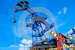 Oil derricks against cloudy sky