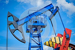 Oil derricks against cloudy sky