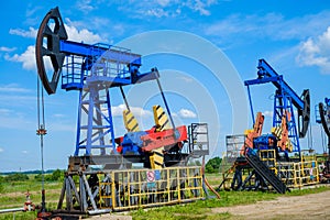 Oil derricks against cloudy sky