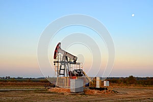 Oil drill rig and pump jack  on sunset background. Oil drilling derricks at desert oilfield for fossil fuels output and crude oil
