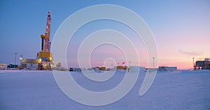 Oil drilling rig. Winter at dawn in the snow