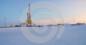Oil drilling rig. Winter at dawn in the snow