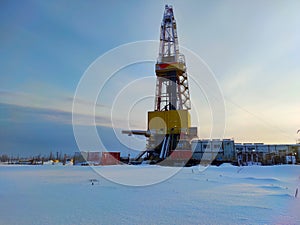 Oil drilling rig. Winter at dawn in the snow