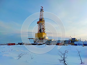 Oil drilling rig. Winter at dawn in the snow