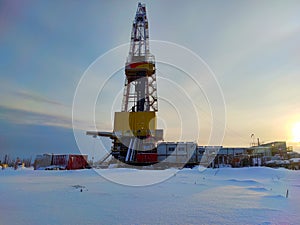 Oil drilling rig. Winter at dawn in the snow