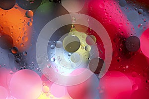 Oil drops in water on a colored background. Bright background with gray, pink, orange and bright pink circles of different sizes.