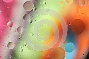 Oil drops in water on a colored background. A bright background with pink, orange, green and blue circles of different sizes. OBlu