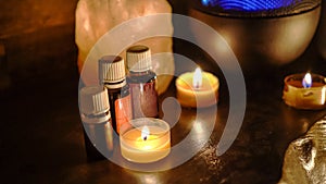Oil essentials and candles on wooden table in room