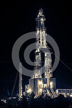 Oil field. Drilling rig at night.