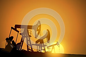 Oil field over sunset. Vector illustration. Gas industry. Dark silhouette drilling rig.