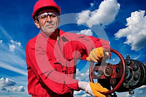 Oil Field Worker Turning Valve On Oil Rig