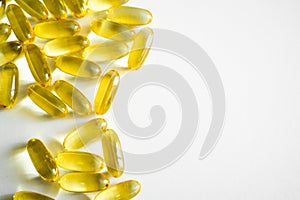 Oil filled capsules, softgel of food supplements. Fish oil, omega 3. Yellow softgels on white, copy space.