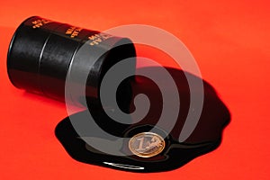 Oil flowing out of the barrel with a one euro coin on a red background