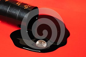 Oil flowing out of the barrel with a one ruble coin on a red background