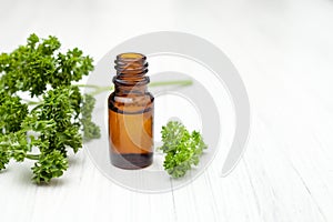 Oil with fresh parsley sprigs on white background