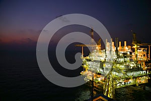 Oil and gas construction in night view. View from helicopter night flight. Oil and gas platform in offshore.