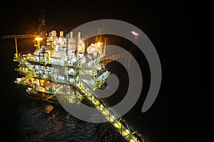 Oil and gas construction in night view. View from helicopter night flight. Oil and gas platform in offshore.