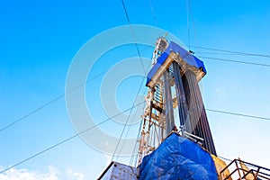 Oil and Gas Drilling Rig onshore dessert with dramatic cloudscape. Oil drilling rig operation on the oil platform in oil and gas