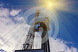 Oil and Gas Drilling Rig onshore dessert with dramatic cloudscape. Oil drilling rig operation on the oil platform in oil and gas