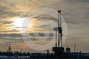 Oil and Gas Drilling Rig onshore dessert with dramatic cloudscape. Oil drilling rig operation on the oil platform in oil and gas