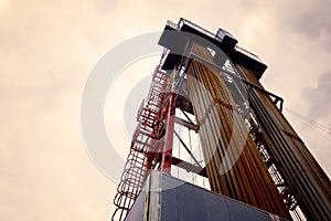 Oil and Gas Drilling Rig onshore dessert with dramatic cloudscape. Oil drilling rig operation on the oil platform in oil and gas