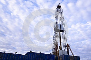 Oil and Gas Drilling Rig onshore dessert with dramatic cloudscape. Oil drilling rig operation on the oil platform in oil and gas