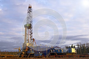 Oil and Gas Drilling Rig onshore dessert with dramatic cloudscape. Oil drilling rig operation on the oil platform in oil and gas