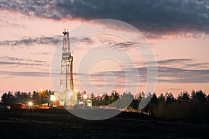 Oil gas drilling rig on sunset background