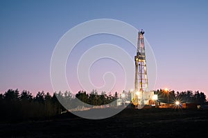 Oil gas drilling rig on sunset background