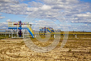 Oil, gas industry. Group wellheads and valve armature, Gas valve, Gas well of high pressure, against the blue sky with clouds
