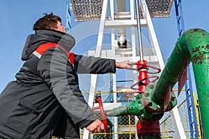 Oil, gas industry. The man controls the process of the oil pump close-up. A man near the oil pump