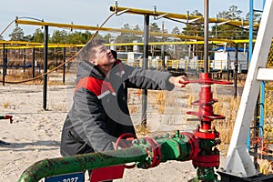 Oil, gas industry. A man near the oil pump. The man controls the process of the oil pump close-up