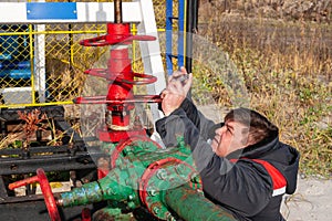 Oil, gas industry. A man photographs on a mobile phone the process of the oil pump close-up. A man near the oil pump