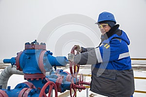 Oil, gas industry. The mechanic - the repairman, gas production operator opens the valve, gas equipment and fitting at the well