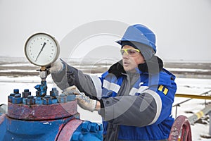 Oil, gas industry. The mechanic - the repairman, gas production operator opens the valve, gas equipment and fitting at the well