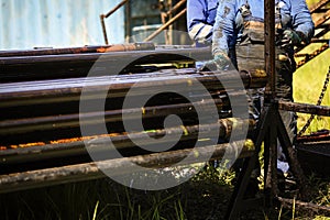 Oil and gas industry worker operates oil rig drill pipes on an oil well rig