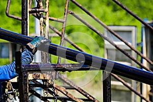 Oil and gas industry worker operates oil rig drill pipes on an oil well rig