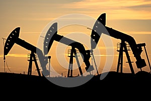 Oil and gas pump jack silhouette on the Canadian prairies in Rocky View County Alberta Canada